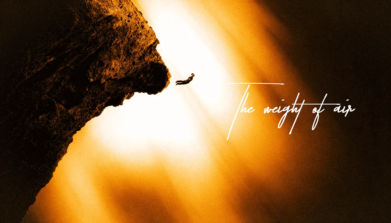 Una figura si lancia nel vuoto da una roccia, controluce caldo, con la scritta The weight of air