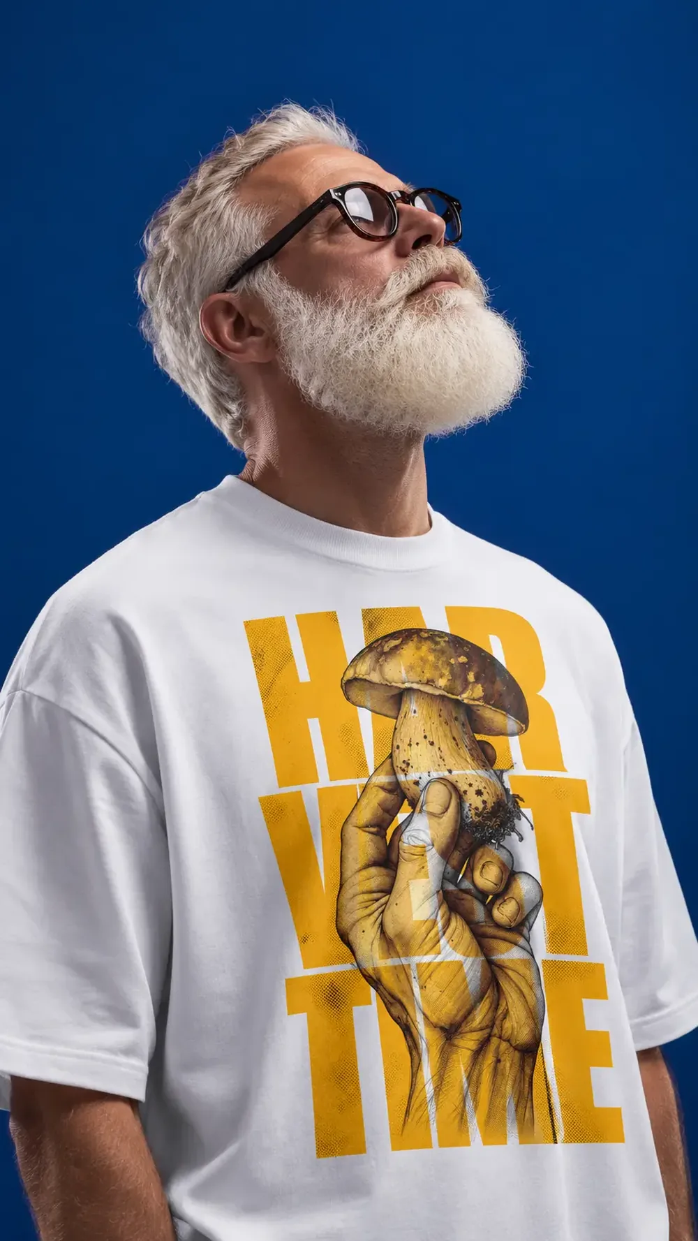 Uomo con la barba bianca e una maglia con la grafica Harvest Time: una mano che regge un fungo