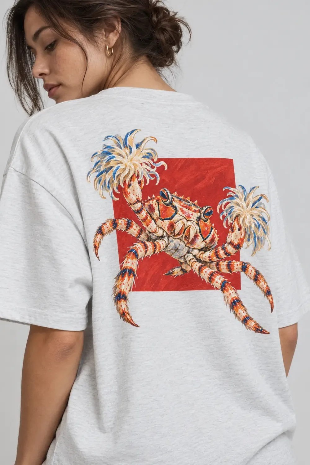 Maglia grigia vista da dietro con la grafica di un granchio pugile con anemoni sulle chele